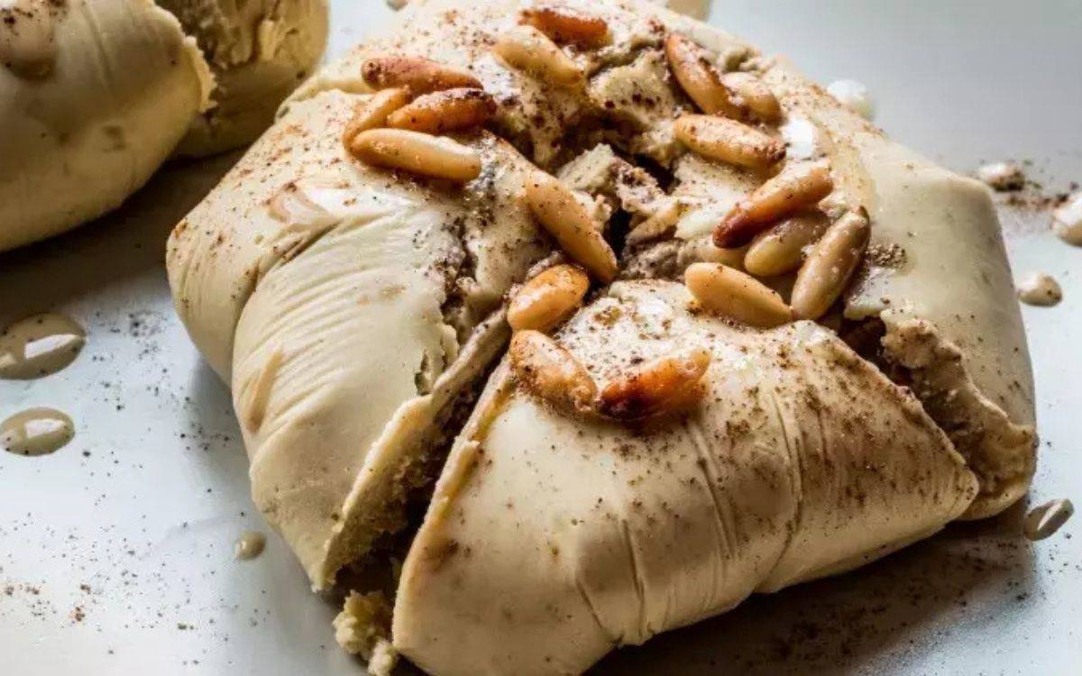 topik yemeği beyaz bir tabakta servis ediliyor. Yanında tarçın çubukları var.